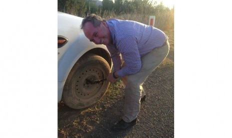 Wakil Perdana Menteri Australia Barnaby Joyce sedang mengganti ban mobil warga di salah satu jalan highway di New England, Queensland.