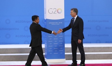 Wakil Presiden Jusuf Kala berjalan menyambut salam Presiden Argentina Mauricio Macri pada KTT G20 di Buenos Aires, Argentina, Jumat (30/11).