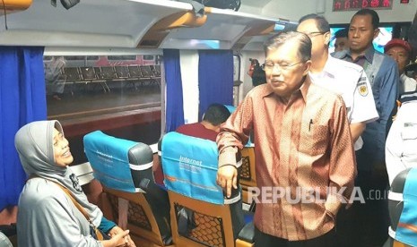 Wakil Presiden Jusuf Kalla berbincang dengan sejumlah pemudik di atas kereta Argo Dwipangga Fakultatif tujuan Surabaya,  saat memantau persiapan arus mudik di Stasiun Gambir, Jakarta, Kamis (7/6)