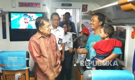 Wakil Presiden Jusuf Kalla berbincang dengan sejumlah pemudik di atas kereta Argo Dwipangga Fakultatif jurusan Surabaya,  saat memantau persiapan arus mudik di Stasiun Gambir, Jakarta, Kamis (7/6).