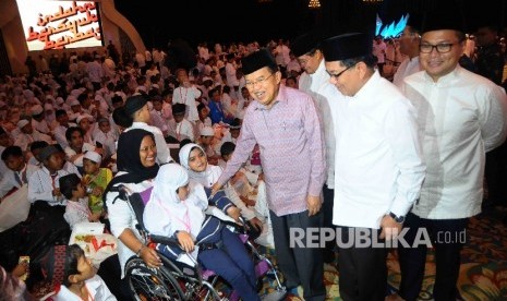 Wakil Presiden Jusuf Kalla bersama Direktur Utama Bank BRI, Asmawi Syam (kedua kanan) serta Direktur Utama Bank Mandiri, Kartika Wiratmodjo (kanan) menyalami anak yatim piatu saat buka puasa bersama Himpunan Bank Bank Milik Negara (Himbara) di Jakarta Conv