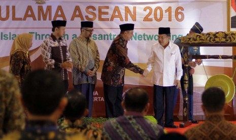 Wakil Presiden Jusuf Kalla (kanan) berjabat tangan dengan Menteri Agama Lukman Hakim Saifuddin (keempat kiri) disaksikan Walikota Bogor Bima Arya (kedua kiri) saat pembukaan Halaqah Ulama ASEAN yang berlangsung 13-15 Desember 2016, di Hotel Salak, 