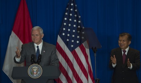 Wakil Presiden Jusuf Kalla (kanan) bertepuk tangan saat Wakil Presiden Amerika Serikat (AS) Michael R. Pence memberi sambutan dalam Business Leaders and Commercial Deal Signing, Jakarta, Jumat (21/4). 