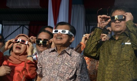 Wakil Presiden Jusuf Kalla (kedua kanan) didampingi Ibu Mufidah Jusuf Kalla (kiri) dan Menteri Komunikasi dan Informatika Rudiantara (kanan) menyaksikan Gerhana Matahari Total (GMT) di Lapangan Dolo, Kabupaten Sigi, Sulawesi Tengah, Rabu, (9/2).