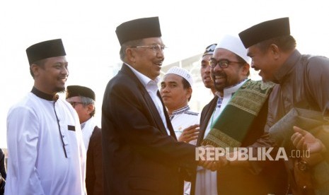 Wakil Presiden Jusuf Kalla (kedua kiri) bersama Wakil Gubernur Sulawesi Selatan Andi Sudirman Sulaiman (kiri) menyalami jemaah shalat Idul Adha 1440 H saat tiba di Lapangan Karebosi, Makassar, Sulawesi Selatan, Ahad (11/8/2019).