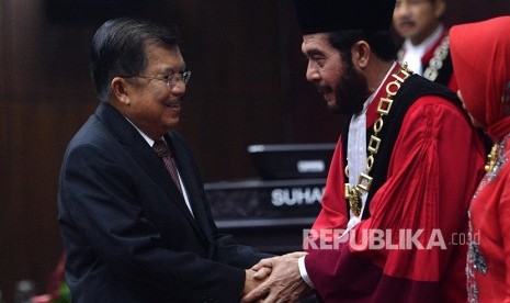 Wakil Presiden Jusuf Kalla (kiri) memberikan ucapan selamat kepada Ketua Mahkamah Konstitusi (MK) terpilih Anwar Usman usai acara pengucapan sumpah jabatan Ketua dan Wakil Ketua MK di gedung MK, Jakarta, Senin (2/4). 