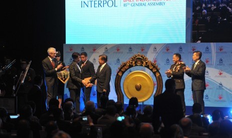 Wakil Presiden Jusuf Kalla (tengah) berjabat tangan dengan Presiden Interpol, Mireille Ballestrazzi (kedua kiri) disaksikan Sekjen Interpol Jurgen Stock (kiri), Kapolri Jendral Pol Tito Karnavian (kedua kanan) dan Gubernur Bali Made Mangku Pastika (kanan) 