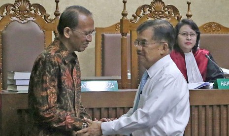 Vice President Jusuf Kalla (white shirt) shakes hands with former minister of religious affairs who became convicted in hajj fund graft case, Suryadharma Ali (left) after testifying in judicial review hearing at Corruption Court, Jakarta, Wednesday (July 11). 