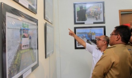 Wali Kota Banda Aceh Aminullah Usman (kanan) didampingi Kepala Biro Antara Aceh Azhari (kedua kanan) melihat karya Pewarta Foto Antara pada pembuka pameran foto HUT ke-81 LKBN Antara di Banda Aceh, Aceh, Senin (17/12/2018). 