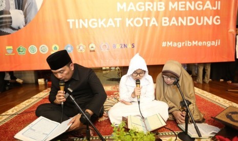 Wali Kota Bandung H Ridwan Kamil tengah membaca Alquran dalam kegiatan pencanangan Gerakan Maghrib Mengaji di Kota Bandung, beberapa waktu lalu.