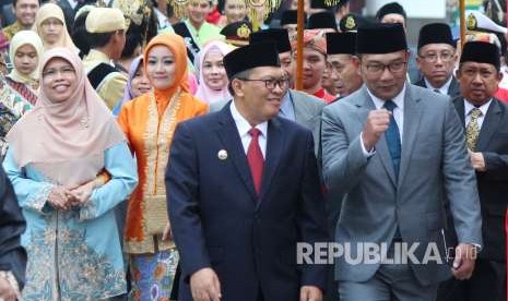 Wali Kota Bandung Oded M Danial berjalan bersama dengan Wali Kota sebelumnya yang saat ini menjabat sebagai Gubernur Jawa Barar Ridwan Kamil (Emil) pada acara serah terima jabatan wali kota yang dirangkaikan dengan pisah sambut di Plaza Balai Kota Bandung, Jumat (21/9).