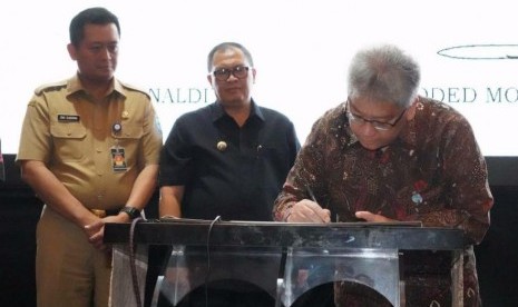 Wali Kota Bandung Oded M Danial (tengah) dan Direktur Utama Bank BJB Yuddy Renaldi (kanan) menandatangani nota kesepahaman (MoU) tentang Pengembangan Kompetensi Pegawai Negeri Sipil di di Hotel Papandayan, Kota Bandung, Selasa (18/2).