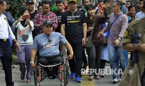 Wali Kota Bandung Ridwan Kamil berjalan menuju Pendopo didamping warga disabilitas di trotoar seusai peresmian revitalisasi Trotoar Kota Bandung di Jalan Ir.H. Djuanda (Dago), Kota Bandung, Ahad (19/2).