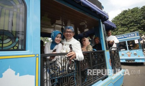 Wali Kota Bandung Ridwan Kamil beserta istri dan para pejabat lainnya menaiki kendaraan Bandung Tour on Bus (Bandros) menuju DPRD Kota Bandung usai upacara Hari Jadi Kota Bandung (HJKB) ke-207, di Balai Kota Bandung, Senin (25/9).