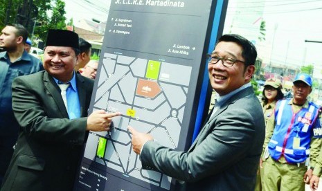 Wali Kota Bandung, Ridwan Kamil (kanan) menunjukan peta jalan di Kota Bandung pada peresmian pedestrian trotoar di kawasan Jl RE Martadinata, Senin (28/12)