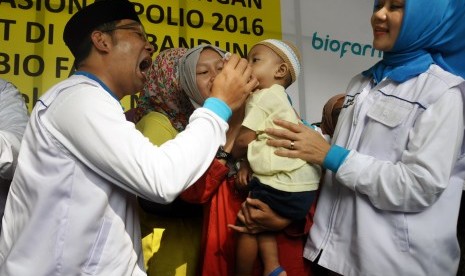 Wali Kota Bandung, Ridwan Kamil (kiri) didampingi istri Artlia Praratya (kanan) memberikan vaksin kepada balita pada Pekan Imunisasi Nasional (PIN) Polio 2016 di Kantor Bio Farma, Bandung, Jawa Barat, Selasa (8/3). 