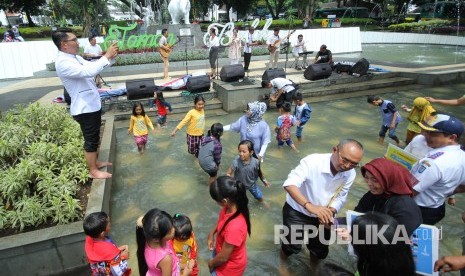 Wali Kota Bandung Ridwan Kamil (kiri) memotret warga yang bermain di kolam dangkal di Taman Badak, Kota Bandung, Selasa (19/12).