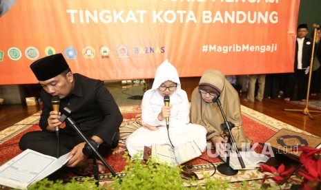 Wali Kota Bandung Ridwan Kamil membaca Alquran pada launcing Magrib Mengaji di Masjid  Al Ukhuwwah, Kota Bandung. (Foto: Pemkot Bandung)