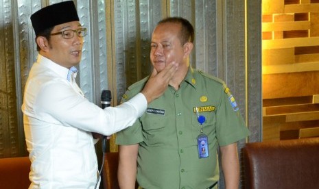 Wali Kota Bandung Ridwan kamil memperagakan cara memegang pipi saat mengingatkan supir angkot omprengan yang membandel, di Kota Bandung, Senin (21/3). Ridwan Kamil membantah telah melakukan penamparan. (Republika/Edi Yusuf)