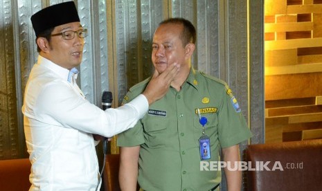 Wali Kota Bandung Ridwan kamil memperagakan cara memegang pipi saat mengingatkan supir angkot omprengan yang membandel, di Kota Bandung, Senin (21/3).