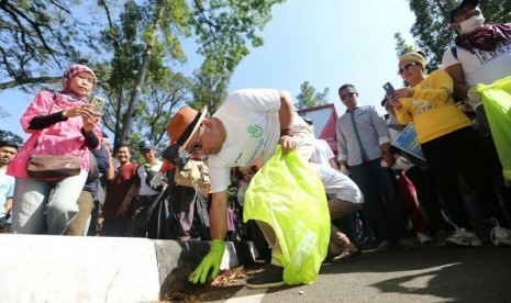 Wali Kota Bandung Ridwan Kamil memungut sampah  bersama ratusan warga di Car Free Day Dago, Ahad (8/10).