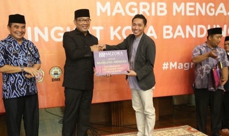 Wali Kota Bandung, Ridwan Kamil, menerima bantuan juzz amma dan mukena yang menjadi program Maghrib Mengaji