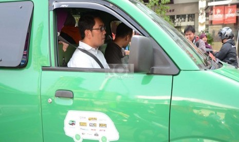  Wali Kota Bandung, Ridwan Kamil menjadi supir angkot dalam acara 'Angkot Day' Jumat (20/9).   (Republika/Edi Yusuf)