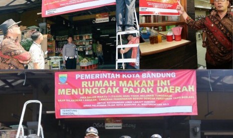 Wali Kota Bandung, Ridwan Kamil memasang spanduk peringatan terhadap sebuah rumah makan di Kota Bandung karena tidak membayar pajak, Kamis (29/9).