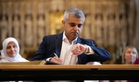 Wali Kota baru London Sadiq Khan melihat jam tangannya dalam upacara penandatanganan jabatannya di Katedral Southwark, London, Sabtu 7 Mei 2016.