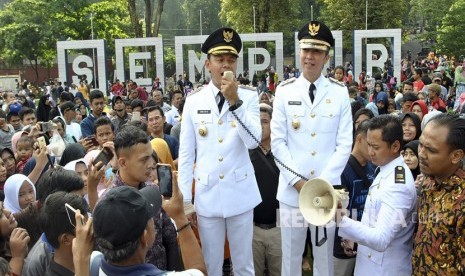 Wali Kota dan Wakil Wali Kota Bogor terpilih 2019-2024 Bima Arya (kiri) dan Dedie A. Rachim (kanan) menyapa warga Bogor saat inagurasi Pelantikan Wali Kota dan Wakil Wali Kota Bogor di Taman Sempur, Kota Bogor, Jawa Barat, Ahad (21/4/2019).