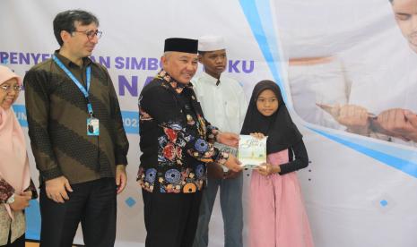 Wali Kota Depok KH Mohammad Idris (tengah) secara simbolis memberikan 500 buku Jalan Nabi secara gratis kepada para anak yatim dan dhuafa, yang berasal dari panti asuhan dan ponpes di sekitar Kota Depok, Jawa Barat, di sela-sela lomba membaca sirah nabi bertema Semua Membacanya di Pribadi Premiere School Depok, Jawa Barat.