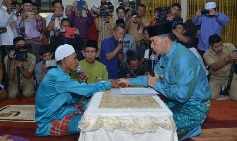 Wali Kota Jambi Syarif Fasha (berpeci hitam) saat memandu pengucapan kalimat syahadat warga Suku Anak Dalam (30/1)