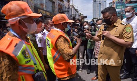 Wali Kota Medan Bobby Nasution (kedua kanan) berbincang dengan petugas parkir elektronik (e-parking) di Jalan Zainul Arifin, Kecamatan Medan Polonia, Kota Medan, Sumatera Utata, Senin (18/10/2021). Pemerintah Kota Medan mulai menerapkan sistem parkir elektronik di 22 titik kawasan Kota Medan.