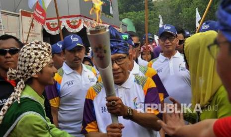 Wali Kota Serang Sulhi Hoir (tengah) disaksikan Gubernur Banten Wahidin Halim (ketiga kanan) membawa obor saat Torch Relay Asian Games 2018 di Stadion Maulana Yusuf, Serang, Banten, Kamis (9/8).