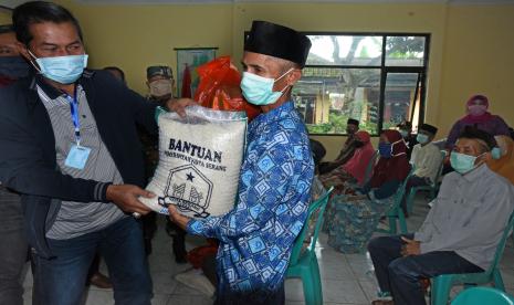 Wali Kota Serang Syafrudin (kiri) menyerahkan bantuan program Jaring Pengaman Sosial (JPS) secara simbolis kepada warga terdampak wabah COVID-19 di Kampung Walantaka, Serang, Banten, Sabtu (2/5/2020). Pemkot Serang membagikan 1.000 paket bantuan berupa beras dan beberapa bahan pokok lainya untuk warga yang kesulitan akibat wabah virus Corona.