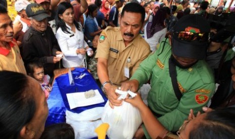 Wali Kota Solo FX Hadi Rudyatmo (tengah) membagikan bungkusan paket sembako saat pembukaan Operasi Pasar Murah di Lapangan Losari, Semanggi, Pasar Kliwon, Solo, Jawa Tengah, Kamis (9/7).