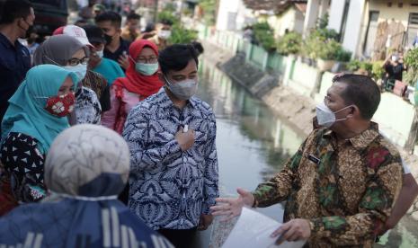  Wali Kota Solo Gibran Rakabuming Raka (kedua kanan) berbincang dengan Wakil Wali Kota Solo Teguh Prakosa (kanan) saat meninjau warga yang tinggal di bantaran sungai Kelurahan Purwosari, Laweyan, Solo, Jawa Tengah, Selasa (25/5/2021).