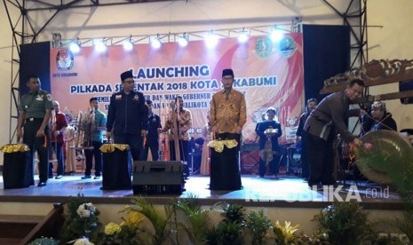 Wali Kota Sukabumi Mohamad Muraz didampingi Ketua KPU Jabar Yayat Hidayat memukul gong tanda launching pilkada serentak 2018 di Kota Sukabumi di Gedung Juang 45 Sukabumi, Ahad (19/11).