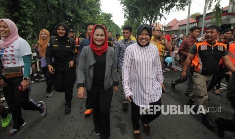 Wali Kota Surabaya Tri Rismaharini (kanan) bersama bakal calon Wakil Gubernur Jawa Timur Puti Guntur Soekarno (kiri) berjalan santai saat Hari Bebas Kendaraan Bermotor atau Car Free Day (CFD), di Darmo, Surabaya, Jawa Timur, Ahad (21/1).