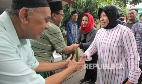 Wali Kota Surabaya Tri Rismaharini (kanan) bersama bakal calon Wakil Gubernur Jawa Timur Puti Guntur Soekarno (kedua kanan) menyapa warga seusai berziarah di Makam Ki Ageng Bungkul, Surabaya, Jawa Timur, Ahad (21/1).