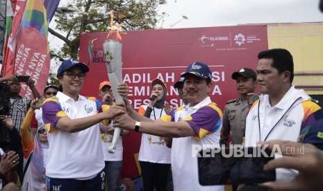 Walikota Bandar Lampung Herman HN (kanan) menyerahkan obor kepada Menteri Keuangan Sri Mulyani (kiri) saat Torch Relay Asian Games 2018 di Bandar Lampung, Lampung, Rabu (8/8).