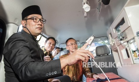 Walikota Bandung Ridwan Kamil (kiri) bersama Direktur PT Astra Daihatsu Motor Shinya Takeda (kanan) dan Marketing dan CR Division Head PT Astra International Hendrayadi Lastiyoso (tengah) meninjau fasilitas ambulans mini ICU seusai penyerahan bantuan dari CSR Daihatsu di Pendopo Kota Bandung, Jawa Barat, Kamis (26/7).