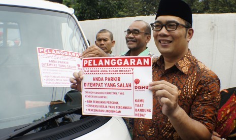 Walikota Bandung Ridwan Kamil menunjukkan stiker pelanggaran kendaraan yang parkir sembarangan di Bandung, Jawa Barat, Jumat (11/3). 