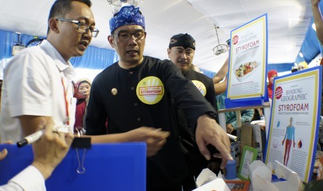 Walikota Bandung Ridwan Kamil (tengah) melihat produk kemasan alternatif pengganti styrofoam pada acara pameran Pengganti wadah Kemasan Pangan Styrofoam di salah satu mall Bandung, Jawa Barat, Rabu (14/12). 