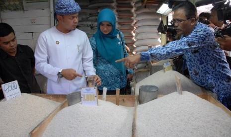 Walikota Bogor, Bima Arya Sugiarto (dua kiri) bersama Kepala Bidang Perdagangan Dinas Perindustrian Perdagangan dan Koperasi Kota Bogor M Sinaga (kanan) memeriksa kualitas dan keamanan beras yang dijual pedagang di Pasar Warung Jambu, Kota Bogor, Jabar, Ra