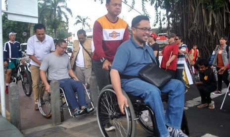 Walikota Bogor Bima Arya (tengah) bersama warga penyandang disabilitas mengikuti jalan sehat melewati fasilitas publik ramah disabilitas di pedestrian Kebun Raya Bogor, jalan Juanda, Kota Bogor, Jawa Barat, Minggu (8/1).