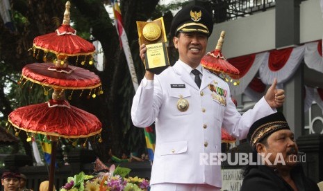 Walikota Malang, Mochamad Anton mengacungkan trofi Adipura Kencana dalam Kirab Budaya Adipura di depan Gedung DPRD, Malang, Jawa Timur, Kamis (3/8). 