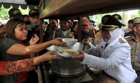 Walikota Surabaya, Tri Rismaharini (kanan) menyerahkan soto bagi masyarakat dalam pesta rakyat usai upacara hari jadi kota Surabaya (HJKS) ke-719 di Taman Surya Balai Kota Surabaya, Jatim, Kamis (31/5).