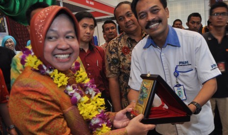 Walikota Surabaya Tri Rismaharini (kiri) menerima plakat dari Pemimpin PT. Permodalan Nasional Madani (Persero) Cabang Surabaya Puji Riyanto (kanan) saat pembukaan Surabaya Great Expo 2015 di Surabaya, Jawa Timur, Rabu (27/5).