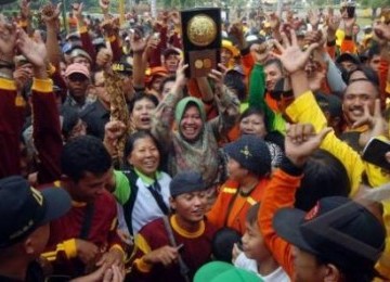 Walikota Surabaya, Tri Rismaharini (tengah), mengangkat penghargaan Adipura bersama sejumlah warga setibanya di Balai Kota Surabaya, Jawa Timur.